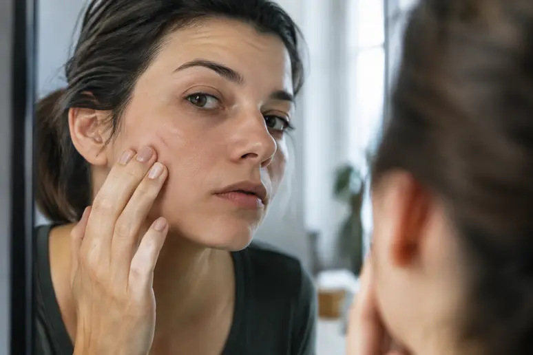 Examen minutieux d'une griffure du visage qui traîne devant un miroir